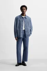 Pantalón azul de corte recto, con cintura ajustable, bolsillos laterales y traseros, y bolsillo tipo plastrón en la pierna. Tiene un lavado vintage con efecto de manchas.