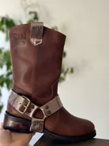 Bota de cuero marrón con estribo desmontable plateado.