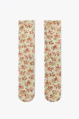 Calcetines finos semitransparentes color crema con estampado floral en tonos rosa y verde.