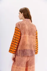 Kimono de viscosa con bordado matelasé vertical y mix de estampas en tonos naranja, rosa y marrón.