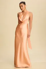 Vestido largo de satén color durazno, con escote halter y espalda descubierta.