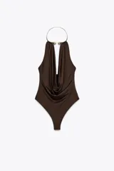 Body marrón de tejido de punto con escote drapeado y collar metálico con apliques de strass. Tiene forro interior y cierre inferior con botones a presión y cierre lateral con cremallera oculta.