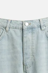 Pantalón cargo de denim color beige, corte relaxed fit, con bolsillos laterales tipo parche con solapa y cierre frontal con botones.