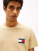 Remera beige de corte slim con cuello redondo y logo de Tommy Jeans en el pecho. Confeccionada en algodón.