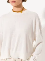 Sweater tejido suave y flojo, color crudo, con cuello redondo y mangas largas.