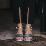 Sandalias de cuero color marrón con plataforma y tacón cuadrado. Tiras anchas sobre los dedos y tobillo con hebilla ajustable.