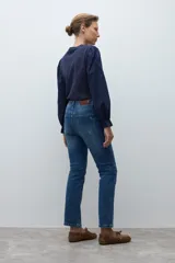 Jean slim de mujer color azul medio, con tiro medio y corte ajustado.