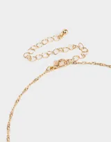 Collar corto dorado con dije de mariposa calada y un cristal en el centro.