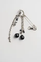 Llavero plateado con dijes de cerezas negras brillantes, cuentas plateadas y negras, y un imperdible.