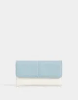 Billetera de cuerina bicolor, con solapa con broche con botón para cerrado y cierre trasero con puller decorativo.