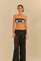 Pantalón negro de corte amplio y fluido, con detalle de encaje floral.