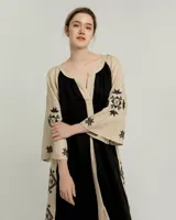 Túnica larga de lino color beige con bordados negros en mangas y ruedo.