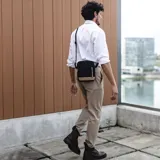 Morral bandolera negro de tela tafeta con detalles en símil cuero color beige. Tiene correa de galón regulable, cierre superior, dos bolsillos frontales con cierre y bolsillos internos.