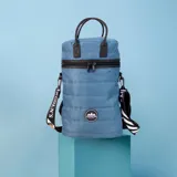 Matera estilo mochila color negro, confeccionada en nylon combinado con símil cuero. Cuenta con tapa con cierre metálico, bolsillo interno, asas y correa extensible.
