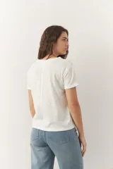 Remera de algodón blanca, de manga corta y cuello redondo, con corte clásico.