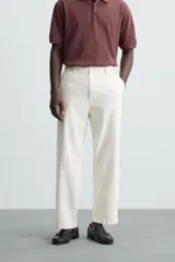 Pantalón de vestir color blanco hueso, de corte relajado (relaxed fit) y tejido de algodón con textura espiga. Presenta bolsillos frontales, bolsillo cerillero y bolsillos traseros de vivo.