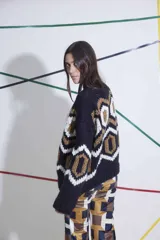 Sweater tejido a mano en lana merino, con cuello redondo y diseño geométrico en colores negro, blanco y marrón. De calce holgado y talle único.