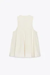 Vestido corto color crema con escote en V y sisas anchas. Tiene forro interior combinado a tono.