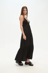 Vestido largo negro de bretel lencero, con escote en V, corte holgado, tajo lateral y detalle de argolla en el busto.