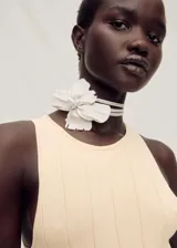 Vestido largo color durazno, de tejido de punto fino con diseño plisado y evasé. Sin mangas y con cuello halter.