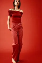 Top rojo de punto elástico con hombros descubiertos, escote ancho con doblez y laterales fruncidos.