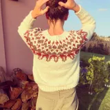 Sweater tejido a mano color mostaza con diseño geométrico en el canesú en tonos azul marino, blanco y verde.