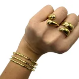 Anillo de acero quirúrgico en color dorado, con diseño curvado y moderno.