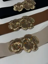 Cinturón elástico con hebilla dorada con forma de dos flores.