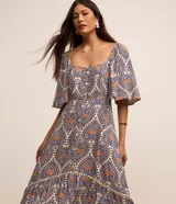 Vestido long midi de viscosa estampada con corazones y piñas, escote corazón, mangas cortas evasé, volado en el ruedo y botones delanteros.