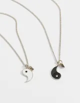 Set de dos collares con dije de yin yang esmaltados en blanco y negro, con cadena plateada y dije con la inscripción 'BFF'.