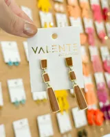 Aros colgantes con tres piezas geométricas color marrón con borde dorado.