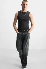Pantalón de jean negro con efecto lavado, corte flare, cinco bolsillos, cierre frontal con cremallera y botón, y bajo con acabado irregular.