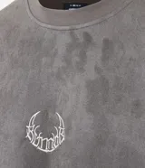 Remera oversized masculina de media malla con toque gamuza, color gris oscuro con efecto lavado. Presenta un bordado blanco en forma de media luna en el pecho y un estampado lettering en la parte delantera y trasera.