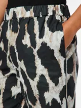 Pantalón recto con estampado animal print en tonos blanco, negro y marrón. Tiene cintura elástica.