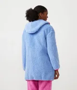 Bata de baño en tejido sherpa color celeste con capucha, cierre delantero y mangas largas. Presenta bies contrastante en color rosa.