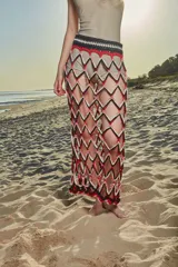 Falda larga de crochet con patrón de rombos en colores rojo, blanco y negro.