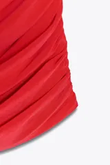 Vestido corto rojo confeccionado en tejido fluido, con cuello halter con lazada, escote drapeado, espalda descubierta y detalle de frunces.