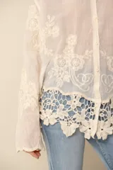 Camisa color crema con bordados florales, de corte holgado y mangas largas.