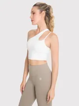 Top deportivo blanco asimétrico de un hombro, con abertura y tirante fino. Incluye sujetador integrado con almohadillas removibles.