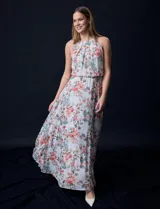 Vestido largo de gasa estampada con flores de colores, escote halter plisado, corte en la cintura elastizado, abertura en la espalda con lazo de ajuste y forro interno a tono.