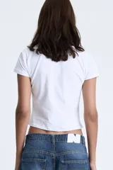 Top de manga corta blanco, ajustado al cuerpo, con estampado frontal en color terracota que dice "nepo baby".