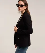 Blazer negro de punto roma con cuello solapa, cierre con ganchos, botones delanteros y forro de poliéster.