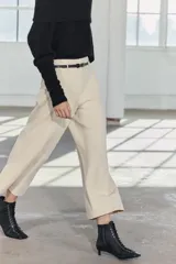 Pantalón culotte color crema, de tiro medio y pierna ancha. Incluye cinturón marrón con hebilla metálica.
