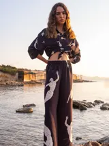 Pantalón palazzo color beige con estampado de girasoles marrones en el ruedo.