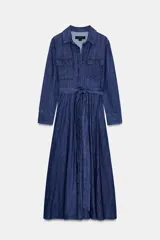 Vestido midi camisero de denim azul con cuello solapa y escote pico. Manga larga, bolsillos de parche con solapa en el delantero y laterales ocultos en costura. Incluye cinturón de la misma tela y cierre frontal con botones ocultos.