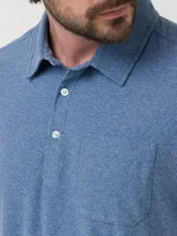 Chomba azul jaspeado de poliéster reciclado y spandex, con cuello polo abotonado, calce moderno y bolsillo de parche en el pecho.