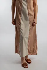 Vestido largo color beige con panel central blanco, sin mangas y corte recto.