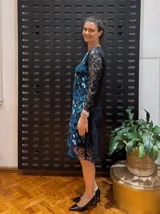 Vestido negro de manga larga, confeccionado en guipur bordado con flores azules y blancas.