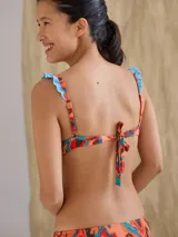 Top de bikini negro con aro, breteles regulables y estampado animal print en los bordes y tirantes.