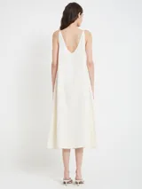 Vestido midi de viscosa, rayón y lino, color crudo, con escote en V en frente y espalda, y caída fluida.